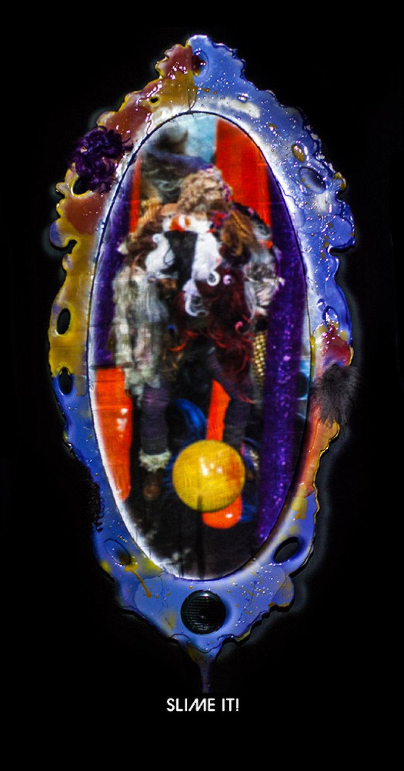 Ornate blue and gold mirror frame with a distorted reflection of a figure holding a yellow orb, text "SLIME IT!" below.