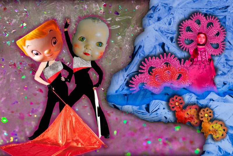 Surreal collage with doll heads on figures in black and silver outfits holding a red flag. To the right, a girl in pink dress with spiral decorations on blue fabric. Background of pink with glitter.