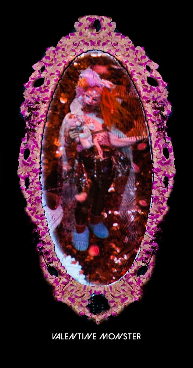 Ornate pink floral mirror frame reflecting a blurry, distorted figure with orange hair, blue shoes, and a white top, against 