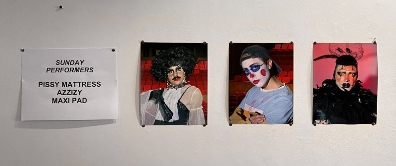 Three portraits of drag performers in colorful makeup and costumes, next to a white sign listing "Sunday Performers.