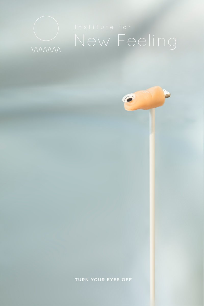 A USB drive with a small, flesh-toned finger attached at the end, pointing left, against a blurred light blue background.